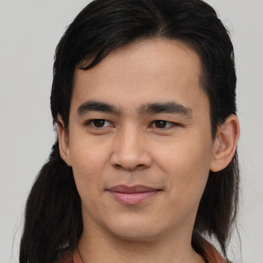 Joyful latino young-adult male with long  black hair and brown eyes