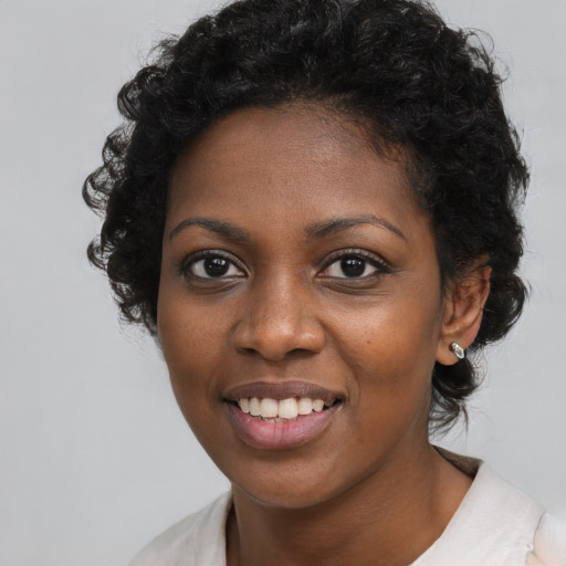Joyful black young-adult female with short  black hair and brown eyes