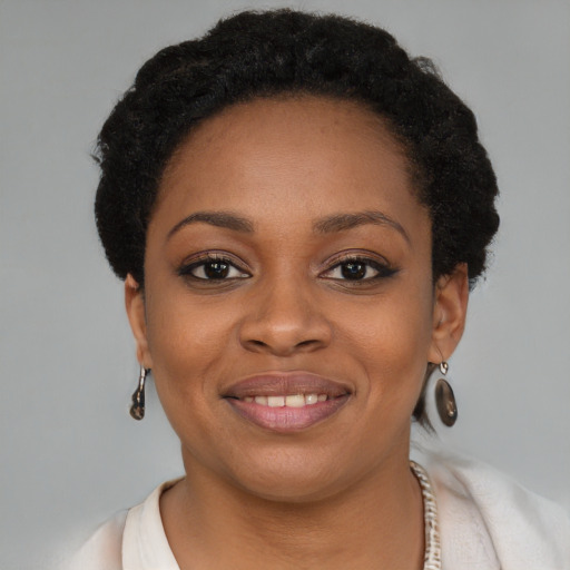 Joyful black young-adult female with short  brown hair and brown eyes