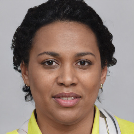 Joyful black adult female with short  brown hair and brown eyes