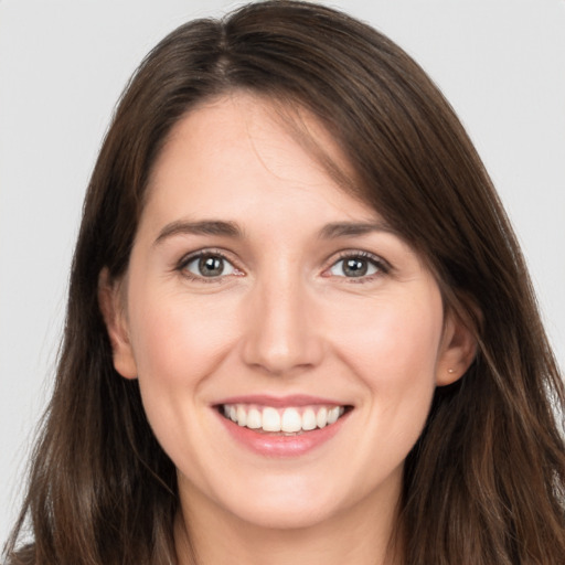 Joyful white young-adult female with long  brown hair and brown eyes