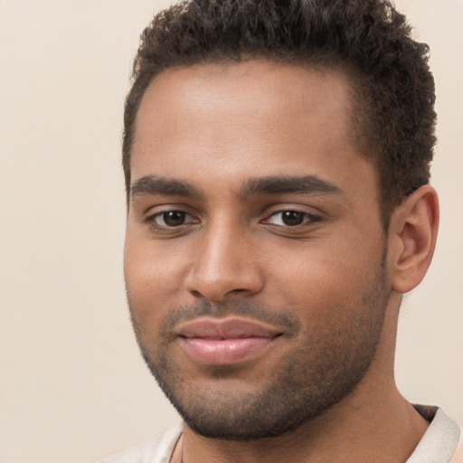 Joyful black young-adult male with short  brown hair and brown eyes