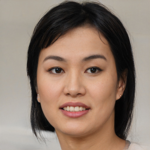 Joyful asian young-adult female with medium  brown hair and brown eyes