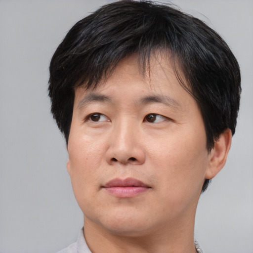 Joyful asian young-adult male with short  brown hair and brown eyes