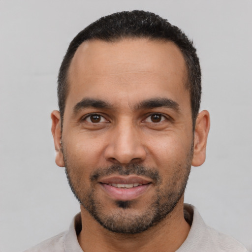 Joyful latino young-adult male with short  black hair and brown eyes