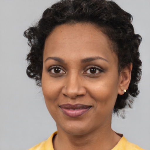 Joyful black young-adult female with short  brown hair and brown eyes