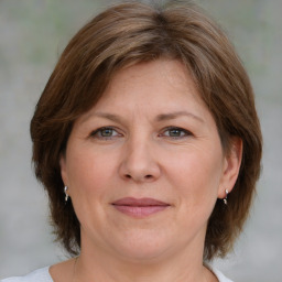 Joyful white adult female with medium  brown hair and green eyes