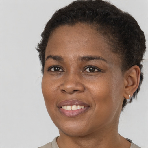 Joyful black young-adult female with short  brown hair and brown eyes