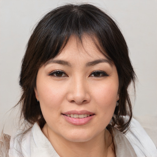 Joyful asian young-adult female with medium  brown hair and brown eyes