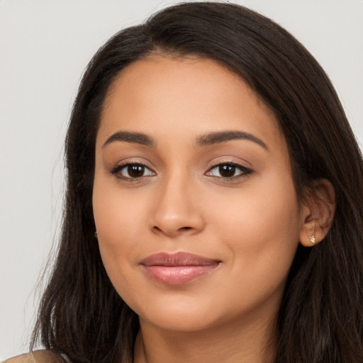 Joyful latino young-adult female with long  brown hair and brown eyes