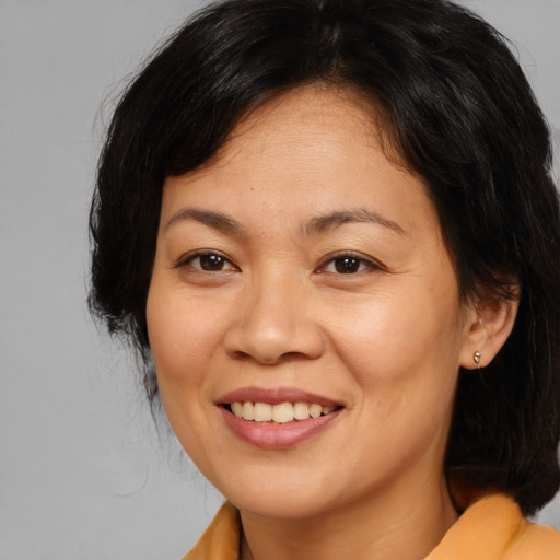 Joyful asian adult female with medium  brown hair and brown eyes