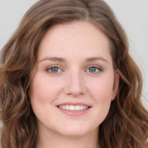 Joyful white young-adult female with long  brown hair and blue eyes