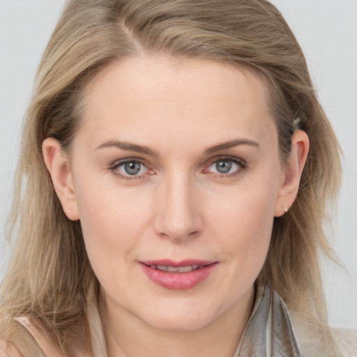 Joyful white young-adult female with long  brown hair and blue eyes