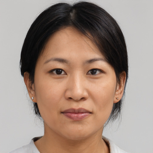 Joyful asian adult female with medium  brown hair and brown eyes