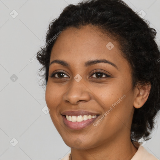 Joyful black young-adult female with long  brown hair and brown eyes