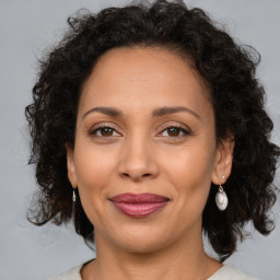 Joyful latino adult female with medium  brown hair and brown eyes