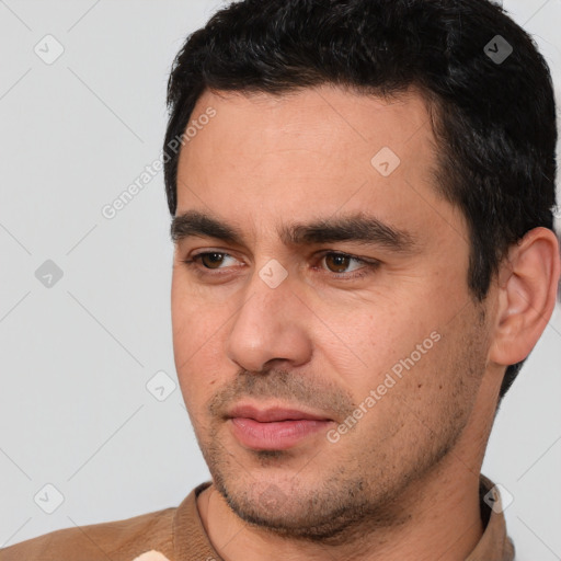 Joyful white young-adult male with short  black hair and brown eyes