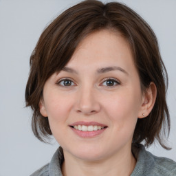 Joyful white young-adult female with medium  brown hair and blue eyes