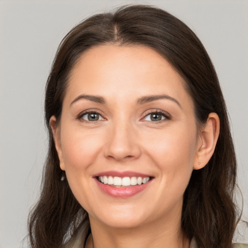 Joyful white young-adult female with long  brown hair and brown eyes