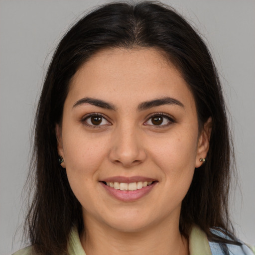 Joyful white young-adult female with long  brown hair and brown eyes