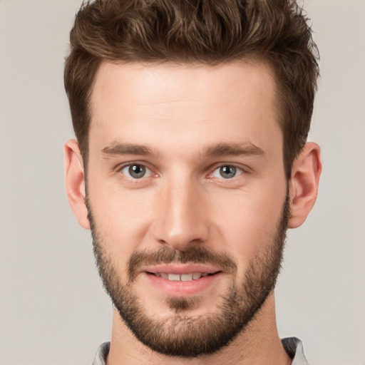 Joyful white young-adult male with short  brown hair and grey eyes