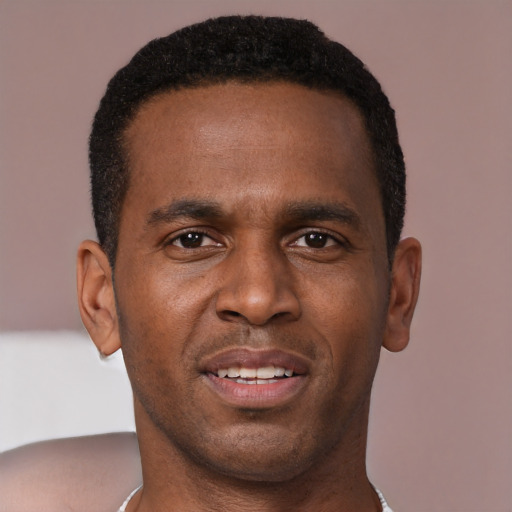 Joyful black young-adult male with short  brown hair and brown eyes