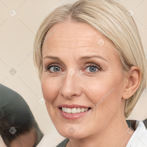 Joyful white adult female with medium  brown hair and blue eyes