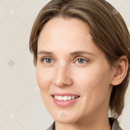 Joyful white young-adult female with medium  brown hair and grey eyes