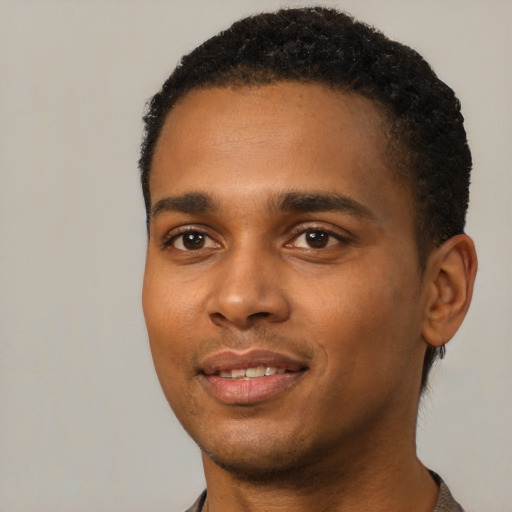 Joyful black young-adult male with short  black hair and brown eyes