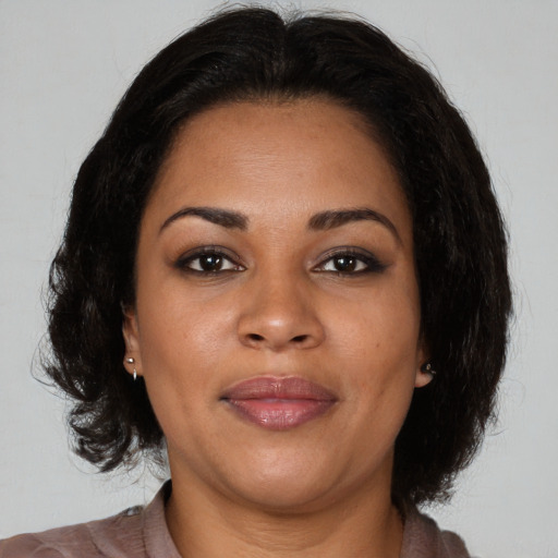 Joyful black adult female with medium  brown hair and brown eyes