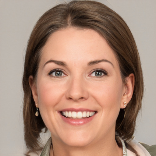 Joyful white adult female with medium  brown hair and green eyes