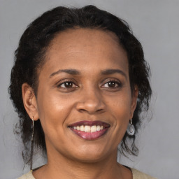 Joyful black adult female with medium  brown hair and brown eyes