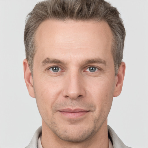 Joyful white adult male with short  brown hair and grey eyes