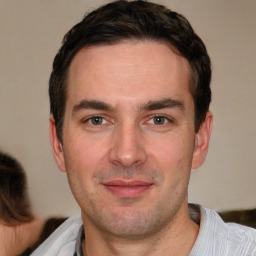 Joyful white adult male with short  brown hair and brown eyes