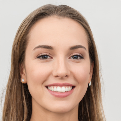 Joyful white young-adult female with long  brown hair and grey eyes