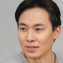 Joyful asian young-adult male with short  brown hair and brown eyes