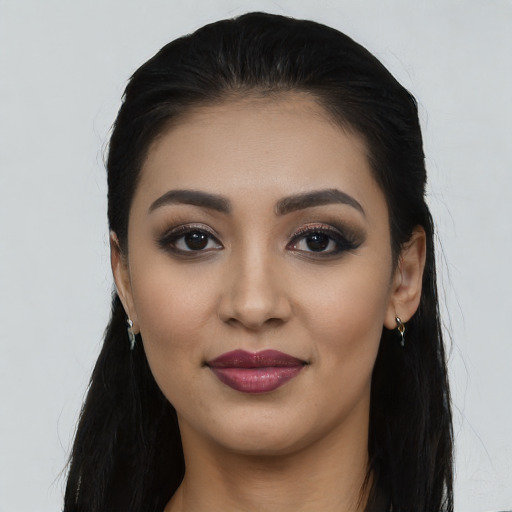 Joyful latino young-adult female with long  black hair and brown eyes