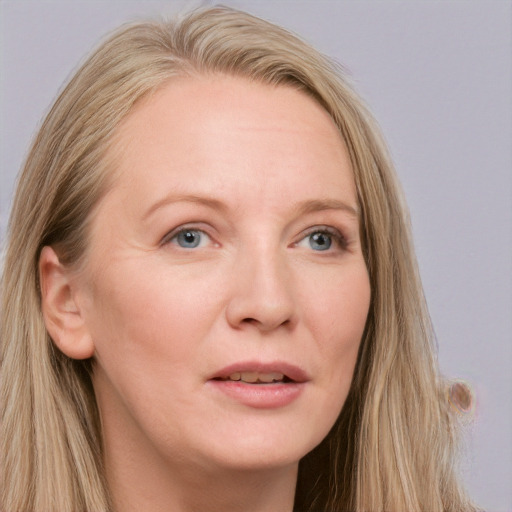 Joyful white adult female with long  brown hair and blue eyes