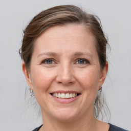 Joyful white adult female with medium  brown hair and grey eyes