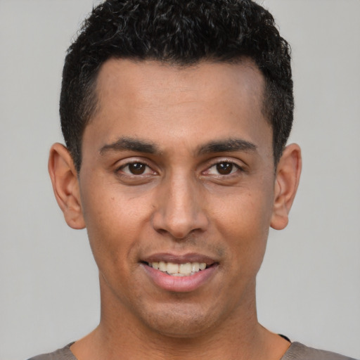 Joyful white young-adult male with short  black hair and brown eyes