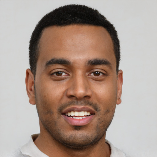 Joyful black young-adult male with short  black hair and brown eyes