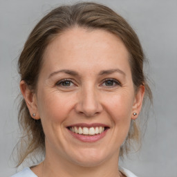 Joyful white adult female with medium  brown hair and grey eyes