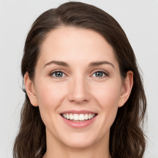 Joyful white young-adult female with long  brown hair and grey eyes