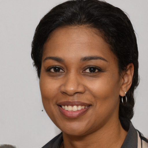 Joyful black young-adult female with medium  brown hair and brown eyes