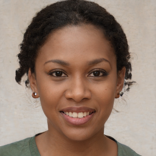 Joyful black young-adult female with short  brown hair and brown eyes