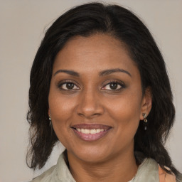 Joyful black young-adult female with medium  brown hair and brown eyes