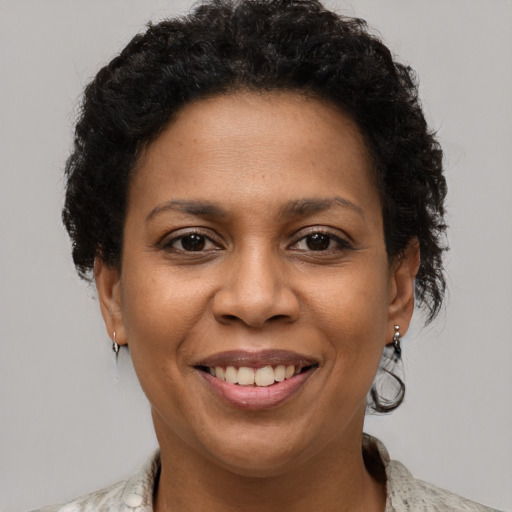 Joyful black young-adult female with short  brown hair and brown eyes