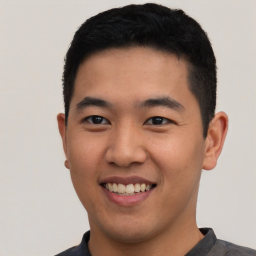 Joyful asian young-adult male with short  black hair and brown eyes