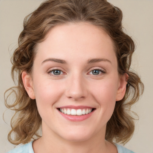 Joyful white young-adult female with medium  brown hair and blue eyes