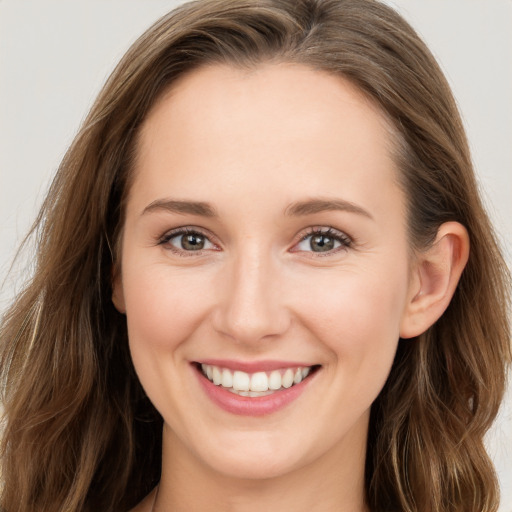 Joyful white young-adult female with long  brown hair and blue eyes